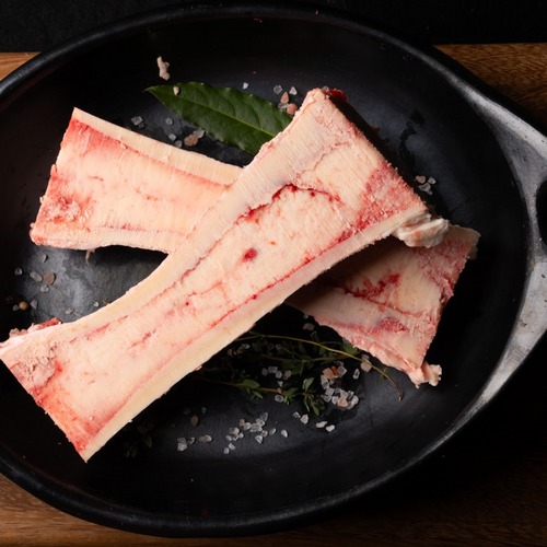 Raw fish fillets on a black plate with herbs and spices