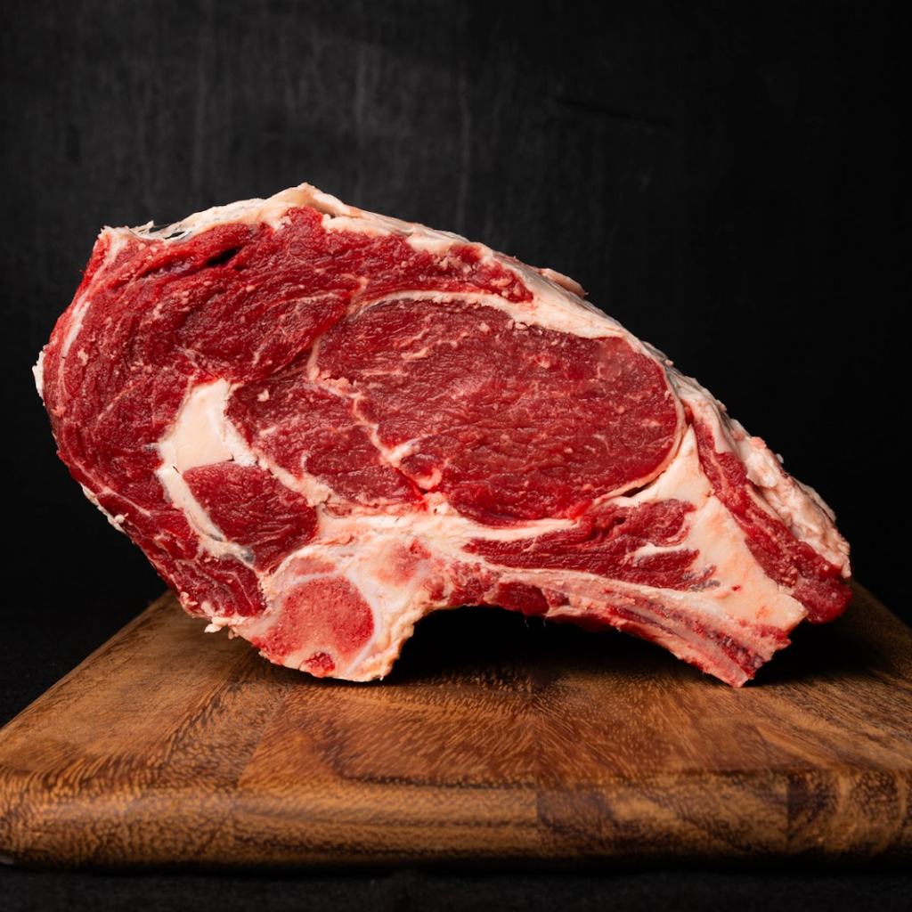 Raw steak on a wooden cutting board with a dark background