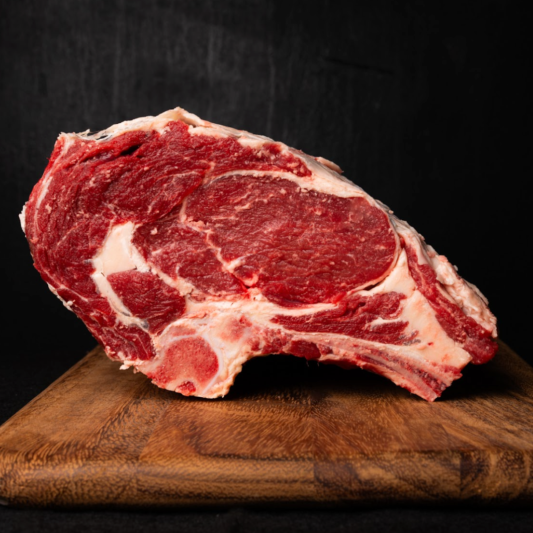 Raw steak on a wooden cutting board with a dark background